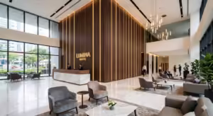 Modern luxury hotel lobby featuring dark walnut Great Wall Panels on a high-ceiling accent wall with integrated LED lighting for architectural depth.
